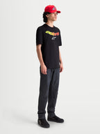 Alpinestars T-Shirt Elliptogrit CSF, t-shirt de sportswear à manches courtes pour homme, noir avec lettrage Astars en dégradé jaune et rouge et logo blanc, style décontracté.