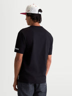 Alpinestars T-Shirt P1 CSF, t-shirt de sportswear à manches courtes mixte, noir, vue de dos avec petit logo Alpinestars Protects sur la manche, construction en coton et polyester, style motorsport décontracté