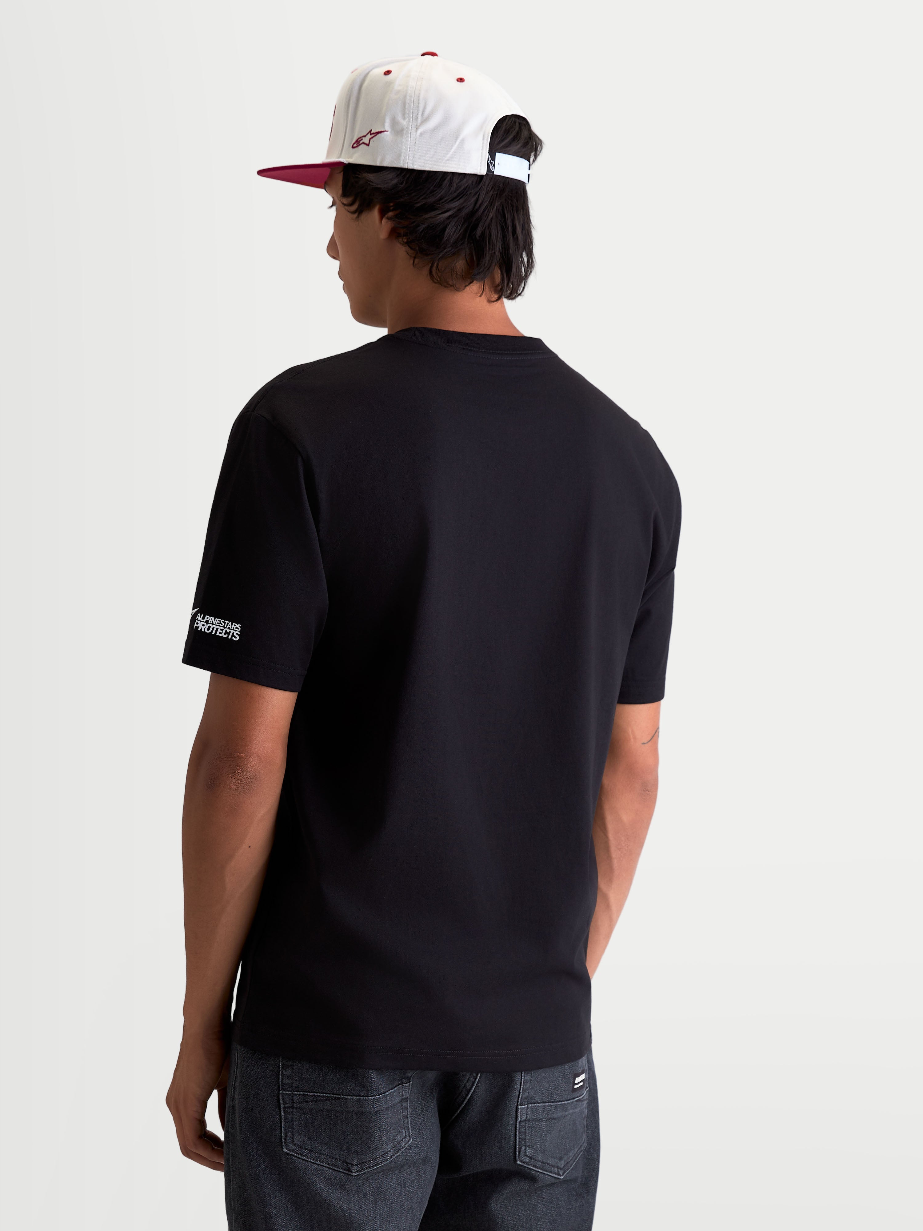 Alpinestars T-Shirt P1 CSF, t-shirt de sportswear à manches courtes mixte, noir, vue de dos avec petit logo Alpinestars Protects sur la manche, construction en coton et polyester, style motorsport décontracté