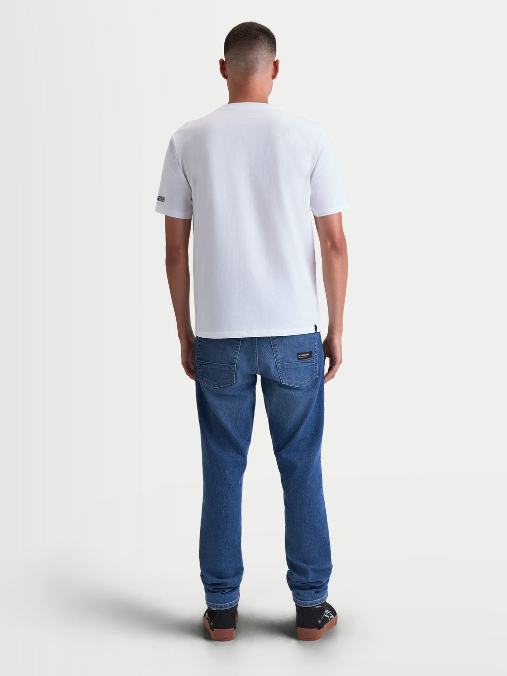 Alpinestars t-shirt P1 CSF, t-shirt de sportswear à manches courtes unisexe, blanc, vue de dos sur modèle, conçu en mélange de coton et polyester, vêtement motorsport décontracté