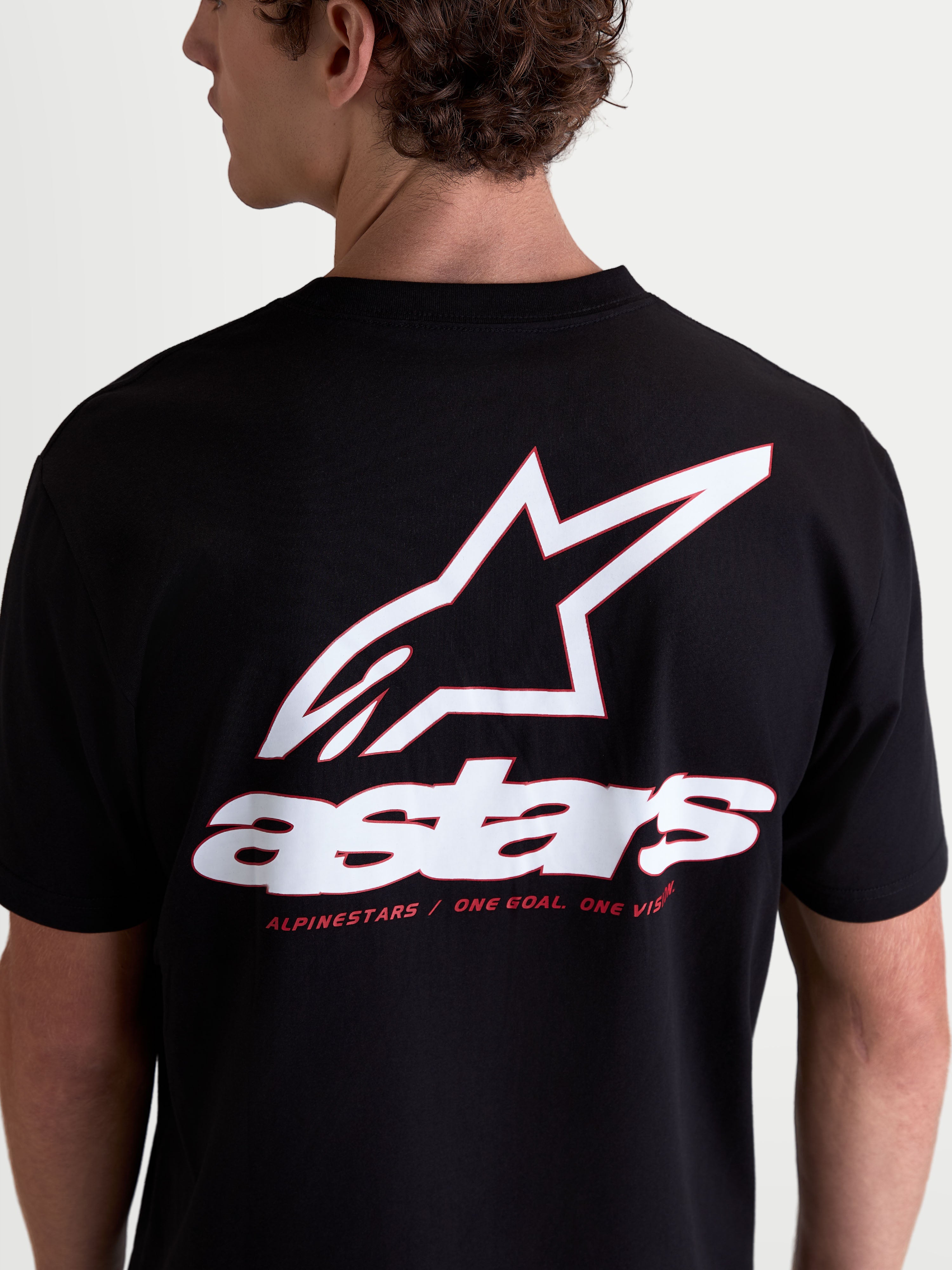 Alpinestars Lineout CSF, t-shirt de sportswear à manches courtes unisexe, noir avec grand graphique logo Astars blanc et rouge au dos, mélange de coton et polyester, devise One Goal One Vision, vue arrière sur modèle