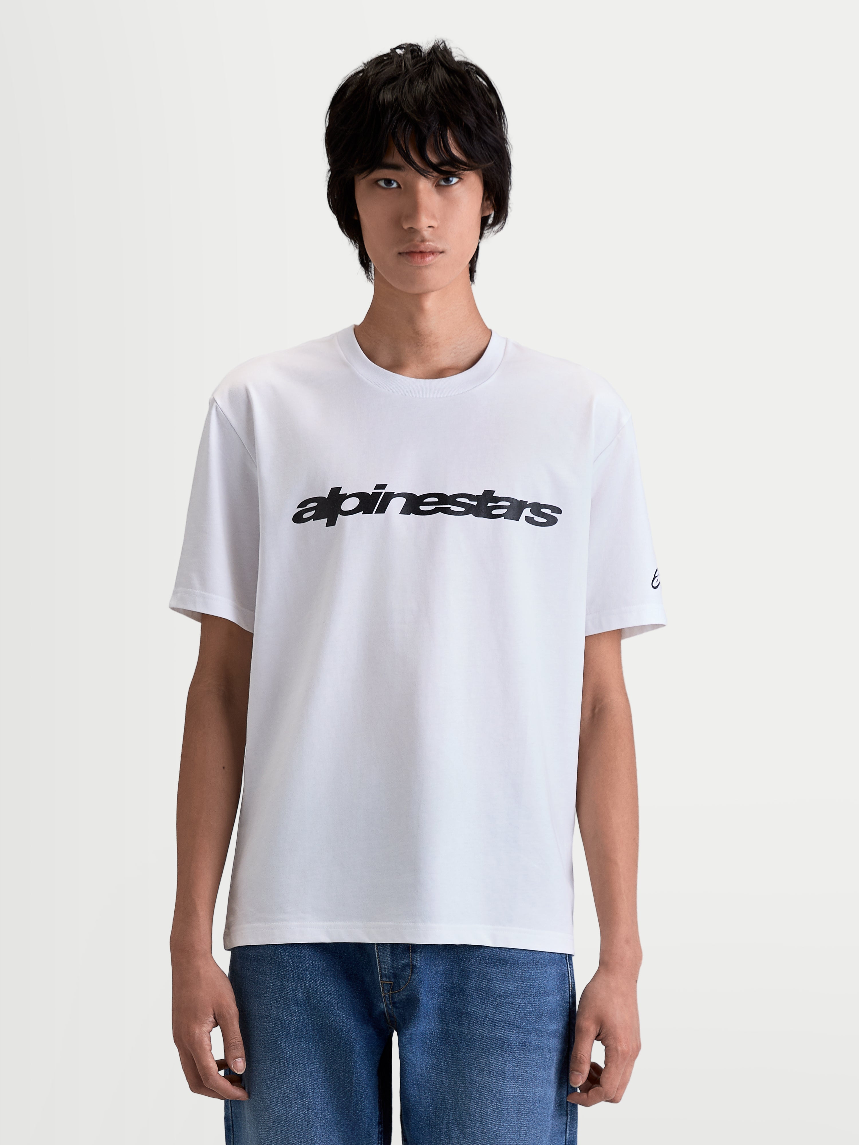 Alpinestars Race Wordmark CSF, t-shirt de sportswear à manches courtes pour homme, blanc et noir, avec graphique wordmark motorsport audacieux sur la poitrine et logo sur la manche, mélange coton-polyester premium, vue de face sur modèle.