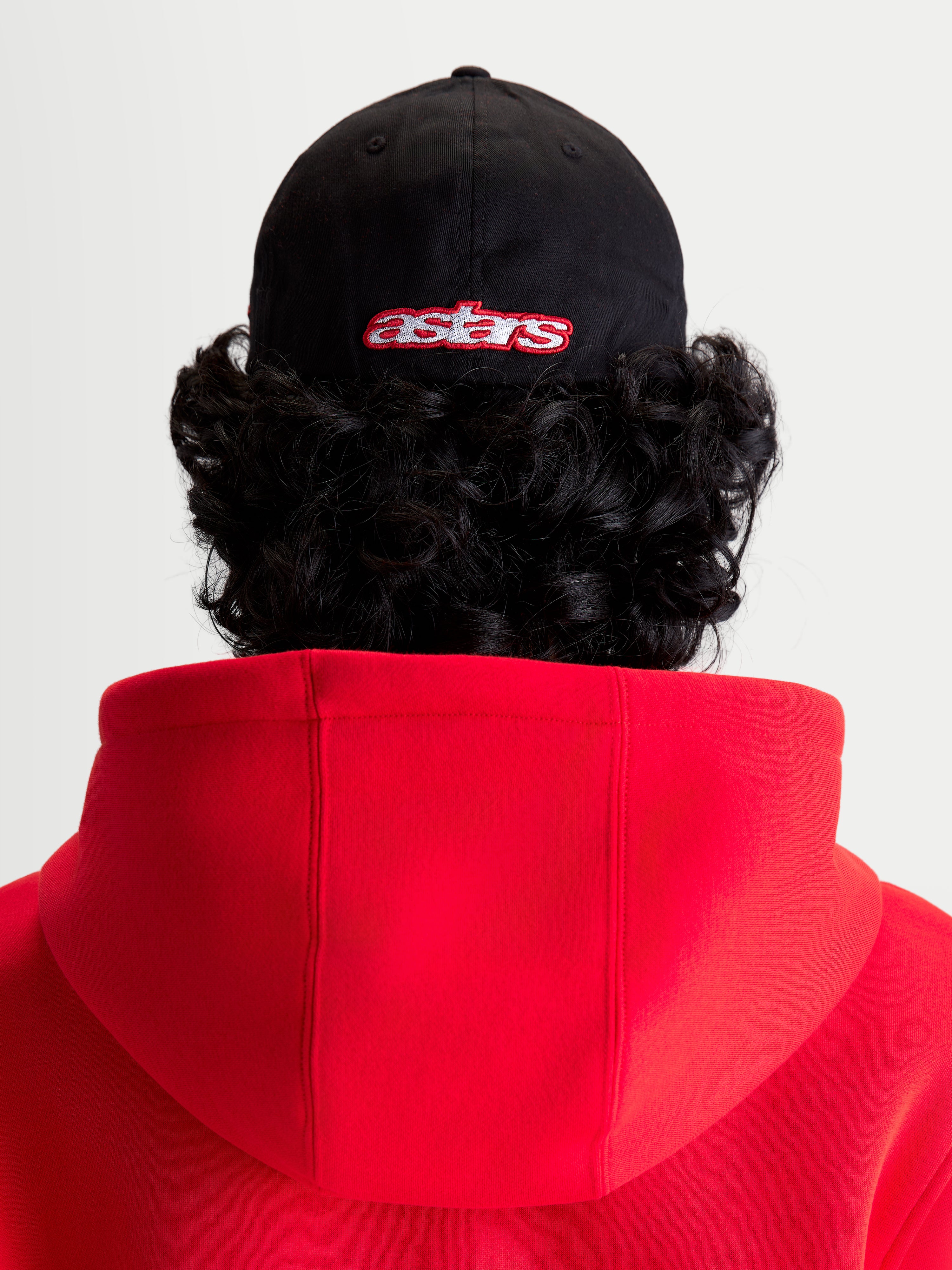 Alpinestars Casquette Lineout, casquette de baseball sportswear noire et rouge, vue arrière sur modèle avec logo Astars brodé, couronne structurée, construction en tissu sergé.