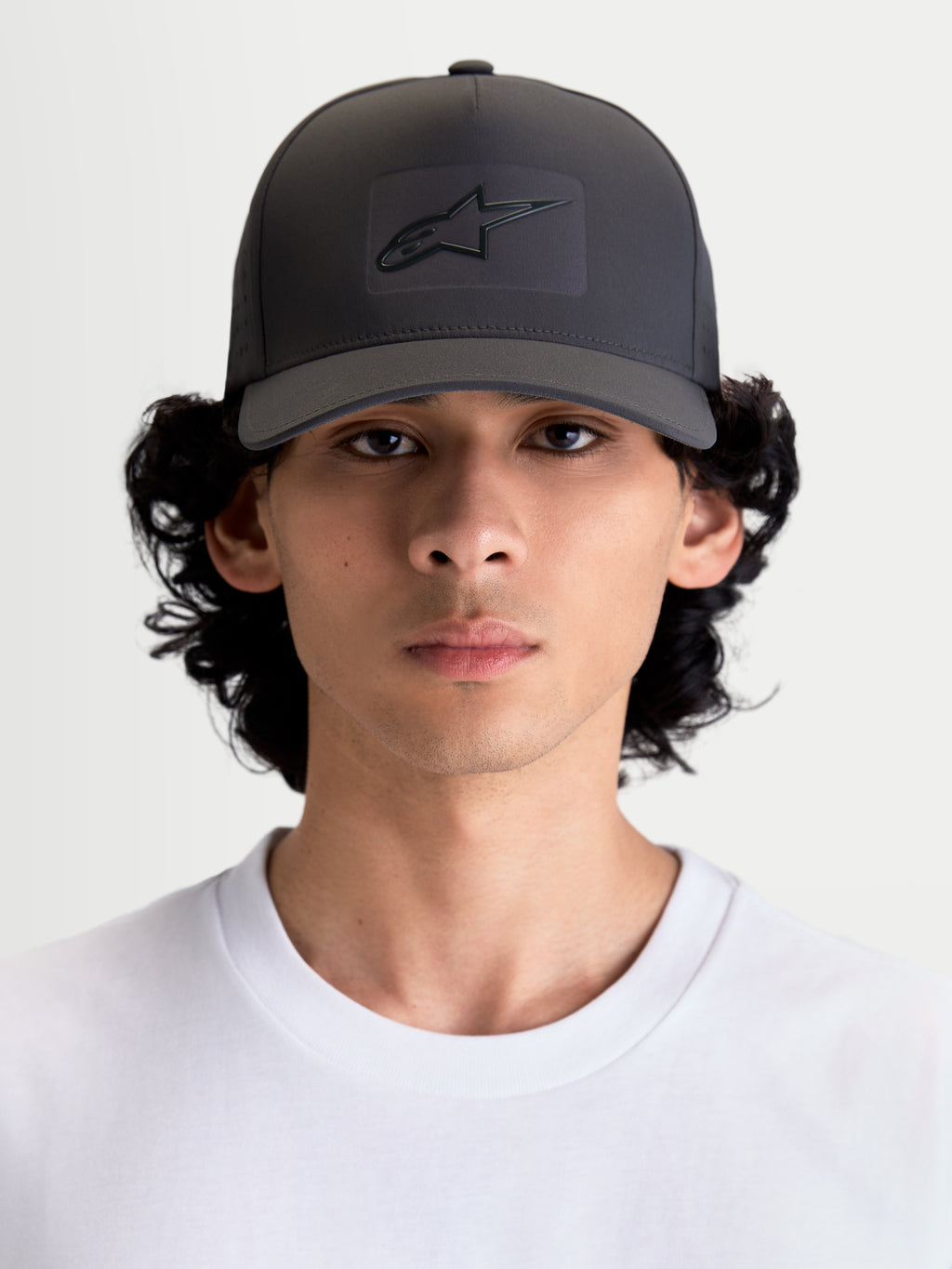 Alpinestars casquette réglable Algo Perf, casquette snapback sportswear pour homme et femme, gris foncé, avec couronne structurée, visière incurvée et logo Astars thermosoudé sur tissu technique, vue de face portée par un modèle.