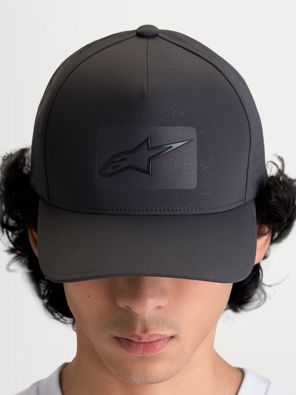Alpinestars Casquette Réglable Algo Perf, casquette de baseball sportswear gris foncé, couronne structurée avec visière incurvée, logo Astars soudé par ultrasons et perforations latérales pour la respirabilité, vue de face portée par un modèle.