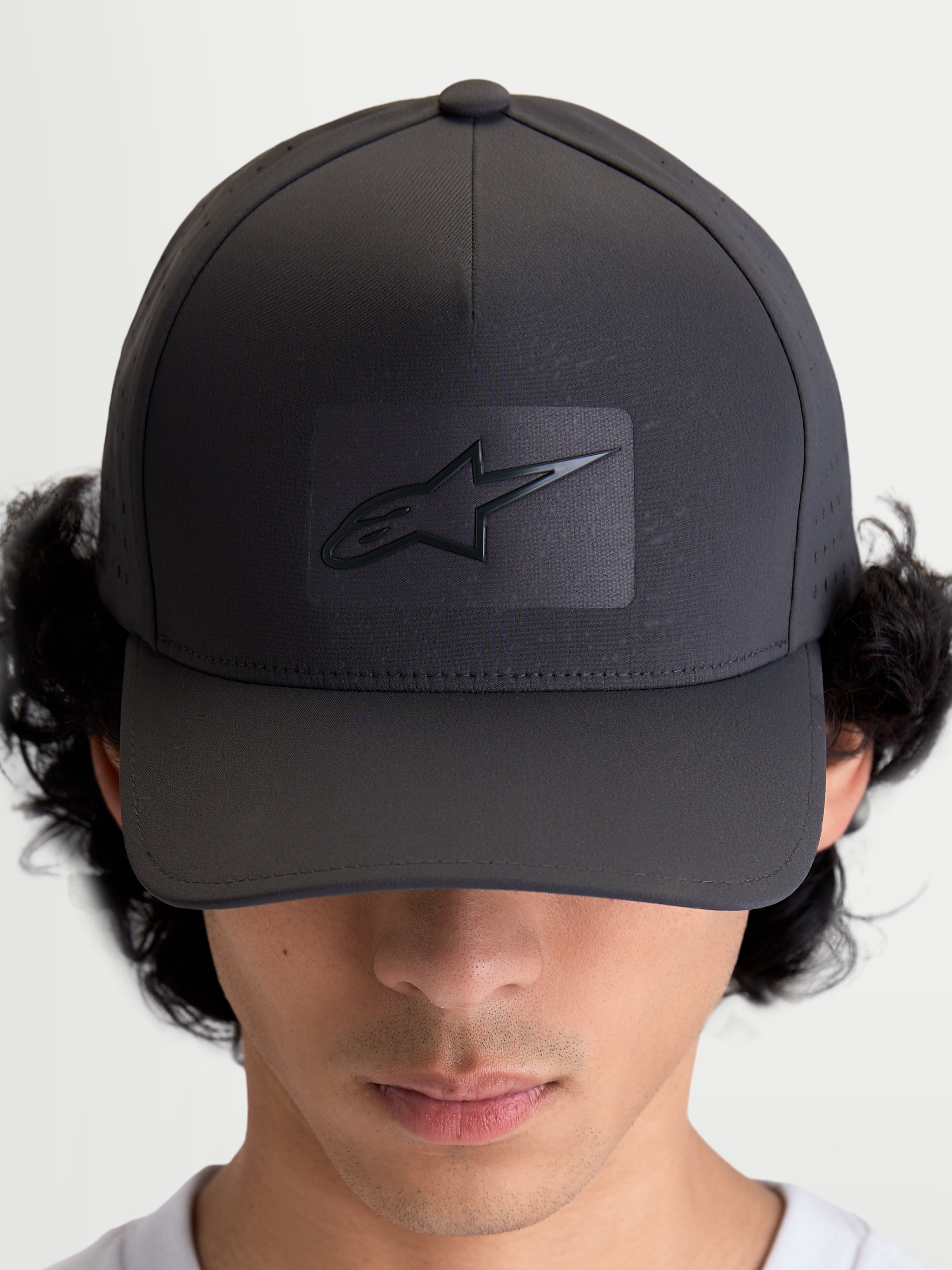 Alpinestars Casquette Réglable Algo Perf, casquette de baseball sportswear gris foncé, couronne structurée avec visière incurvée, logo Astars soudé par ultrasons et perforations latérales pour la respirabilité, vue de face portée par un modèle.