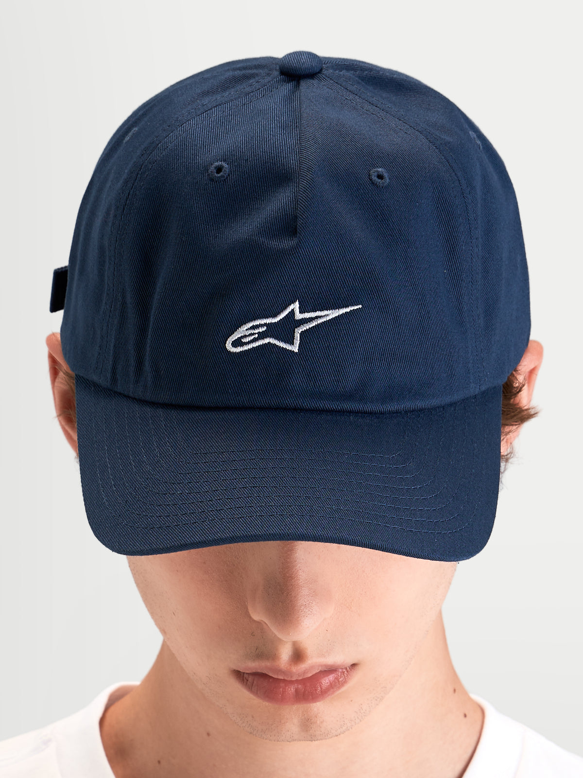 Alpinestars Dylan Dad Hat, casual sportswear cap worn by a model, blue cotton twill with curved bill and embroidered white Astars logo on the front