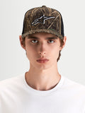 Alpinestars Casquette Trucker Thicket Realtree, casquette sportswear camouflage et noire, portée par un modèle mettant en valeur la couronne structurée et le logo Astars brodé sur le panneau avant