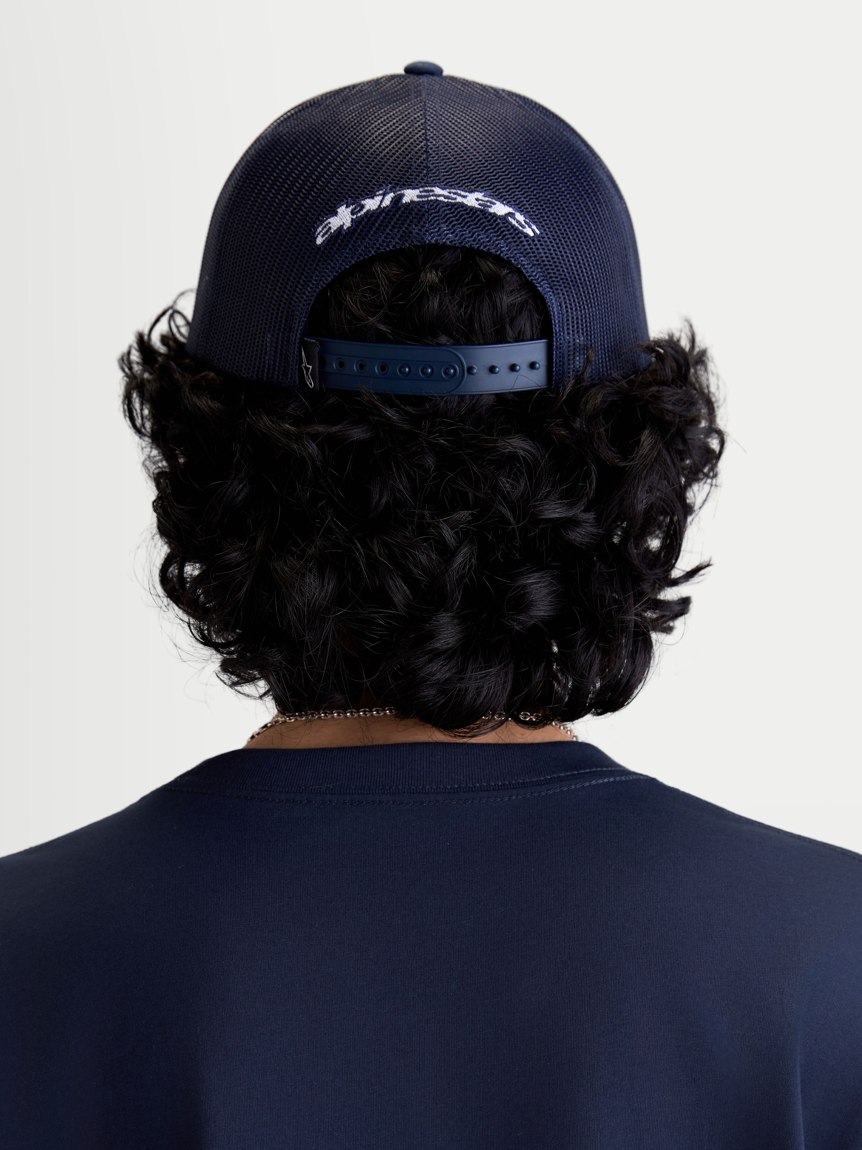 Alpinestars Casquette Trucker Meteorite, casquette de sportswear décontractée, vue de dos sur un modèle, bleu marine, arrière en maille polyester et fermeture snapback réglable avec logo brodé blanc