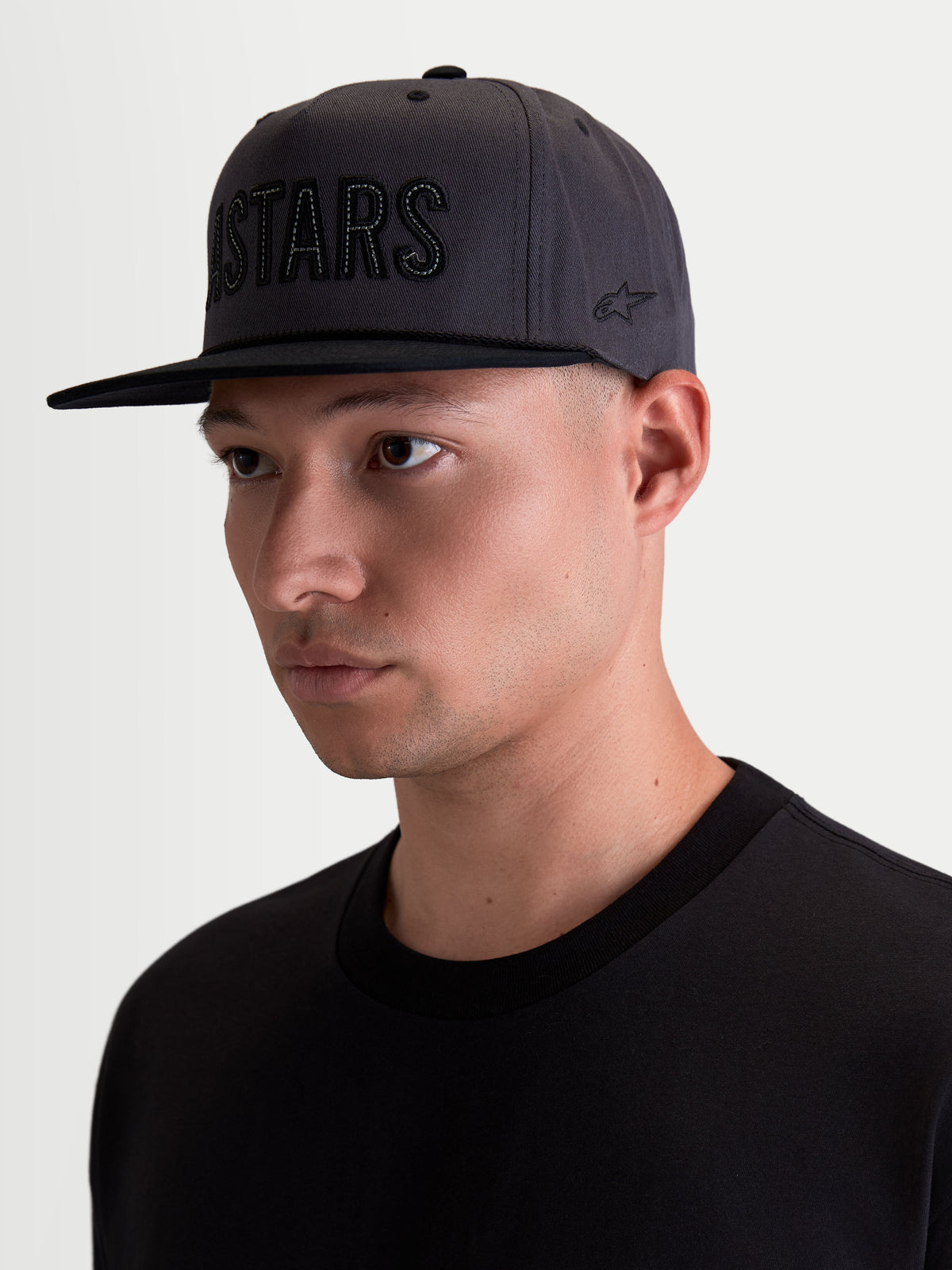 Alpinestars casquette Stadium Snapback, casquette de sportswear pour homme, gris foncé et noire, couronne structurée avec visière plate, logo Astars appliqué et broderie latérale, sergé de coton, vue sur modèle