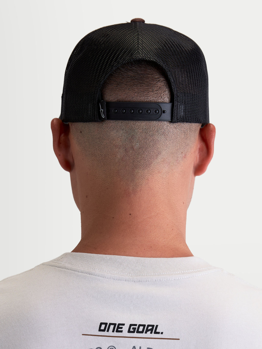 Alpinestars Casquette Trucker Hotlink, casquette lifestyle sportswear unisexe, marron et noire, vue de dos montrant la fermeture snapback réglable et les empiècements en maille filet pour la respirabilité.