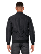 Veste Precedent Alpinestars, noir, vue de dos sur modèle, dotée d'un motif matelassé en angle iconique, poignets et ourlet en côtes, style motorsport matelassé inspiré de la F1