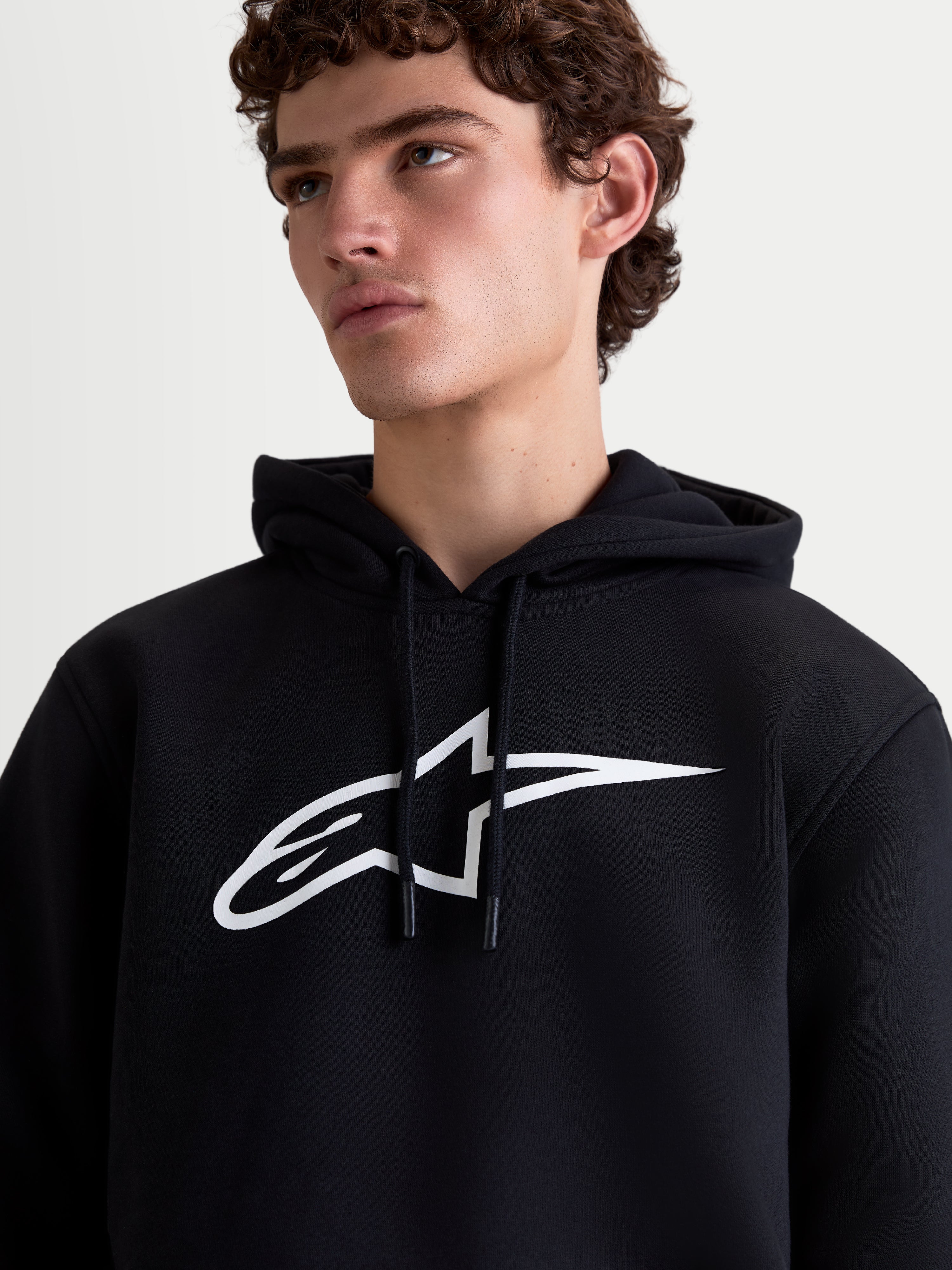 Alpinestars sweat à capuche Ageless V3, sweat sportswear en polaire pour homme, noir et blanc, vue rapprochée avec grand logo blanc sur la poitrine et capuche à cordon de serrage