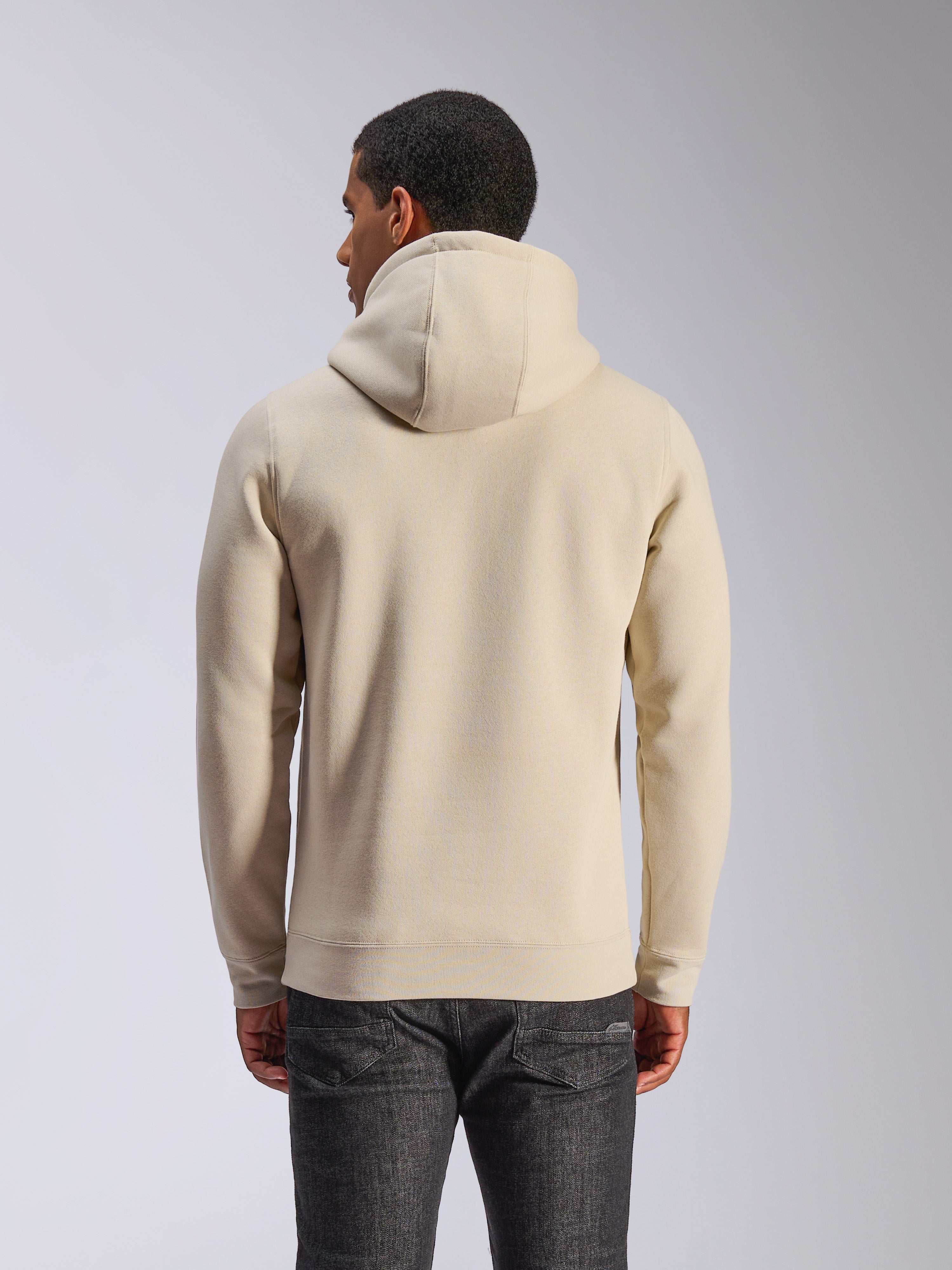 Sweat à capuche Alpinestars Ageless V3, blanc cassé, vue de dos, sportswear décontracté, doté d'une capuche doublée de jersey, manches longues avec poignets et ourlet côtelés, porté avec un jean en denim foncé