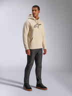 Sweat à capuche Alpinestars Ageless V3, streetwear décontracté, blanc cassé avec logo brodé noir, polaire à capuche, manches longues, poche kangourou sur le devant, porté avec un jean foncé et des baskets noires