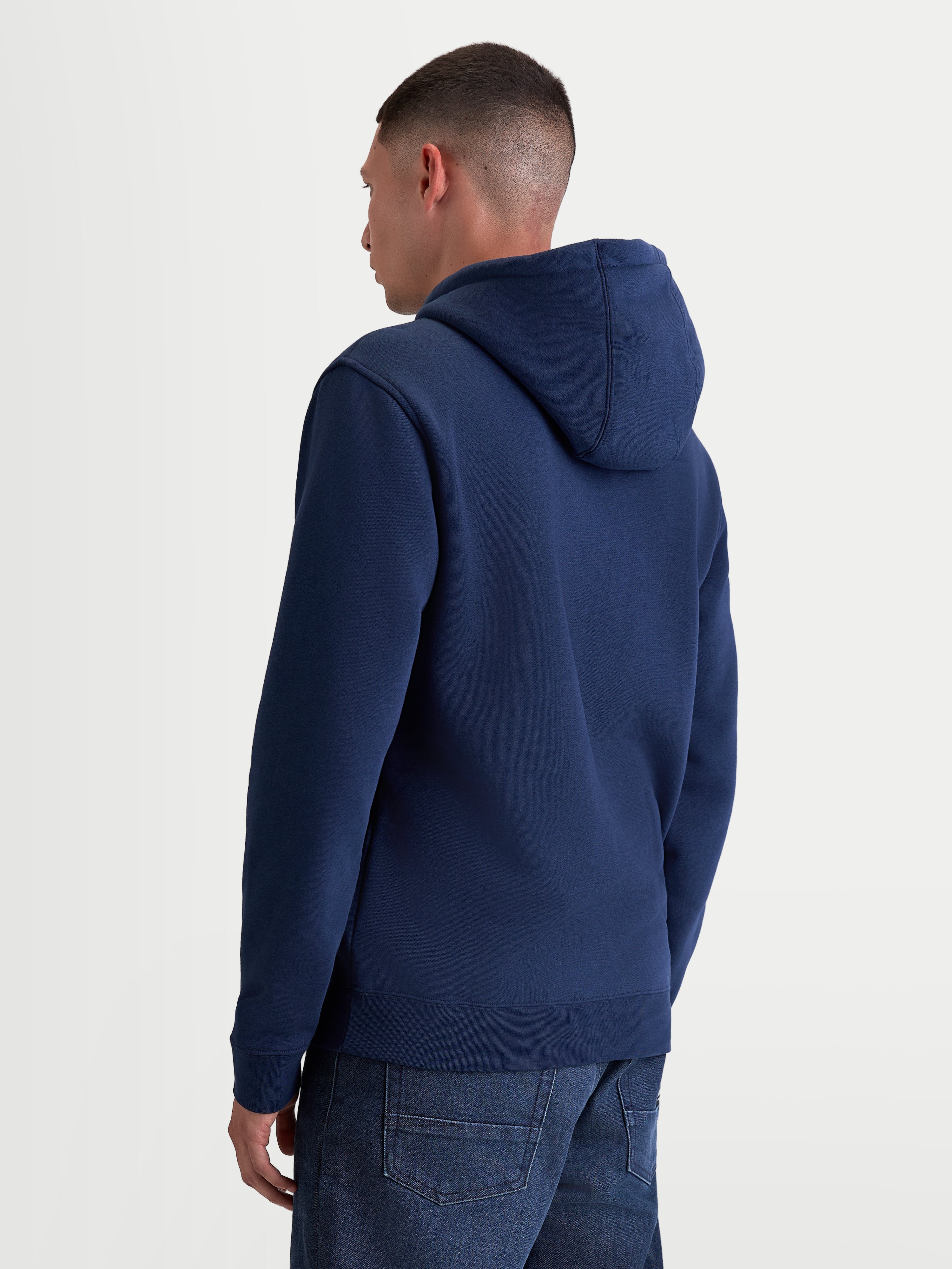 Alpinestars Sweat à capuche Ageless V3, sweat sportswear en polaire bleu marine, vue de dos sur un modèle, avec capuche doublée, poignets et ourlet côtelés, mélange de coton premium et polyester recyclé.