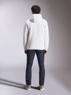 Sweat à capuche Alpinestars Blaze V3, hoodie blanc décontracté style sportswear, vue de dos du pull en polaire, design épuré avec poignets et ourlet côtelés, porté avec un jean bleu foncé et des baskets, vêtement lifestyle moderne inspiré du sport automobile