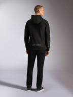 Alpinestars Sessions V3 Hoodie, casual streetwear, black with grey Alpinestars wordmark on the lower back and 'astars' branding on the sleeves, back view of male model wearing hoodie and black pants, modern motorsport-inspired design