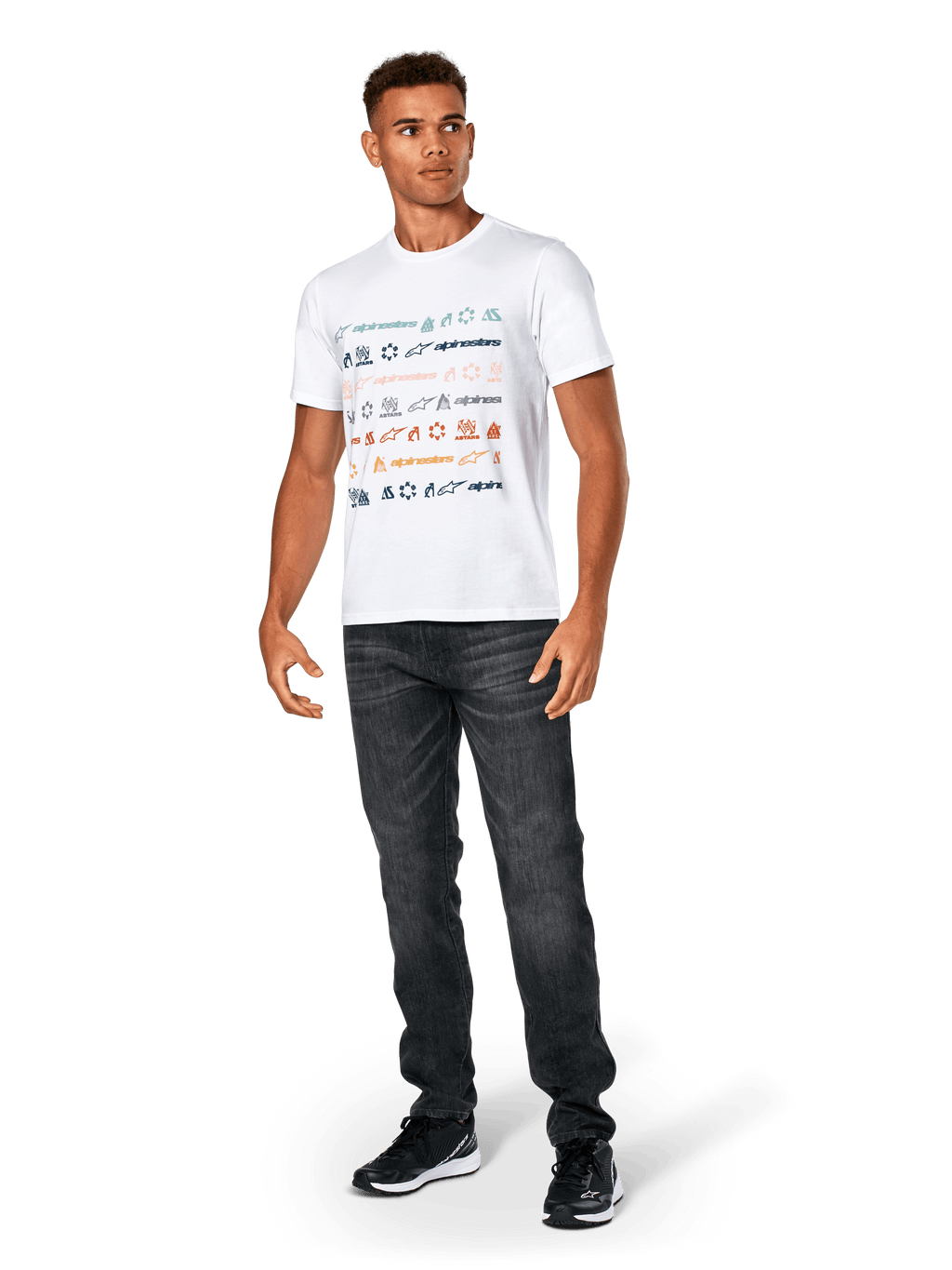 T-shirt Alpinestars Glyfs CSF, à manches courtes, blanc, avec graphique à rayures multi-logo sur le devant, porté avec un jean gris foncé et des baskets noires, vêtement sportswear décontracté inspiré du sport automobile