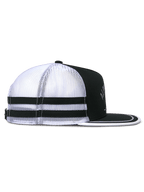 Casquette Trucker Alpinestars Backline, vue de profil, noir, blanc et gris, avec arrière en maille blanche et deux bandes horizontales noires, couronne noire structurée et visière plate avec bordure blanche, couvre-chef décontracté d'inspiration sport automobile