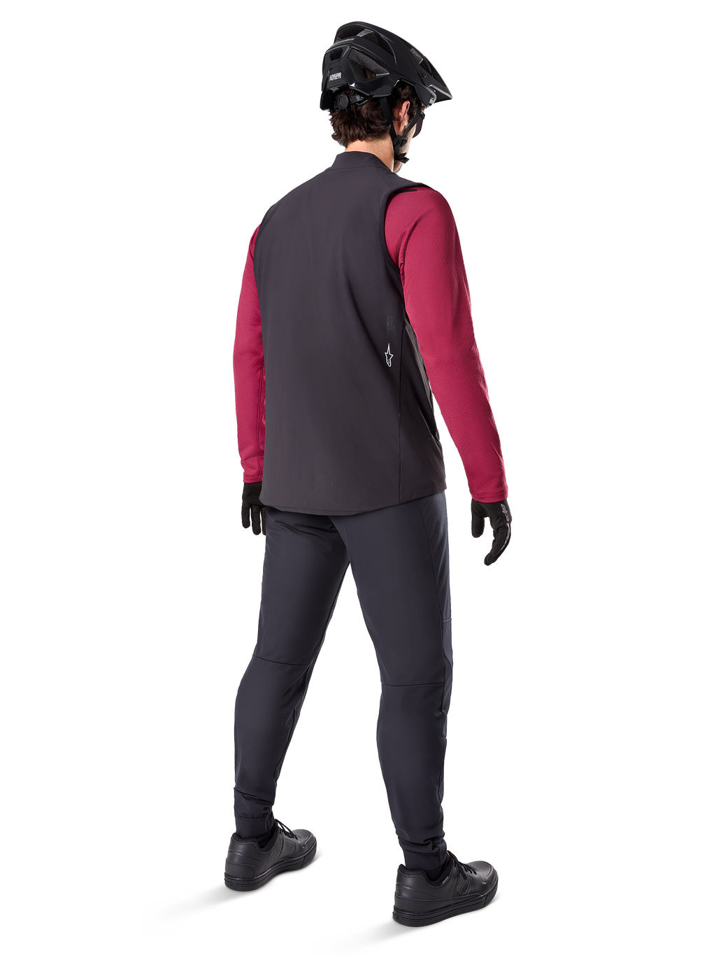 Gilet thermique Alpinestars A-Dura, gilet de cyclisme noir, vu de dos sur un modèle portant un maillot à manches longues bordeaux et un pantalon de cyclisme noir, associé à un casque de VTT et des gants noirs, équipement technique pour rouler par temps froid