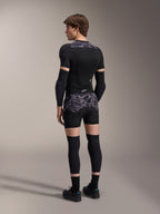 Mannequin portant le boxer de protection A-Motion Plasma Alpinestars en motif Black Camo et la veste de protection A-Motion Plasma assortie, vue de dos montrant le camouflage gris, les coudières, les genouillères et les chaussures de cyclisme, équipement de protection complet pour VTT.
