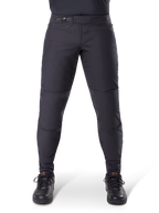 Pantalon thermique Alpinestars A-Dura, pantalon de VTT noir avec fermeture à cliquet sécurisée et coupe pré-courbée, porté avec des chaussures de cyclisme noires, matériau technique durable pour le VTT par temps froid