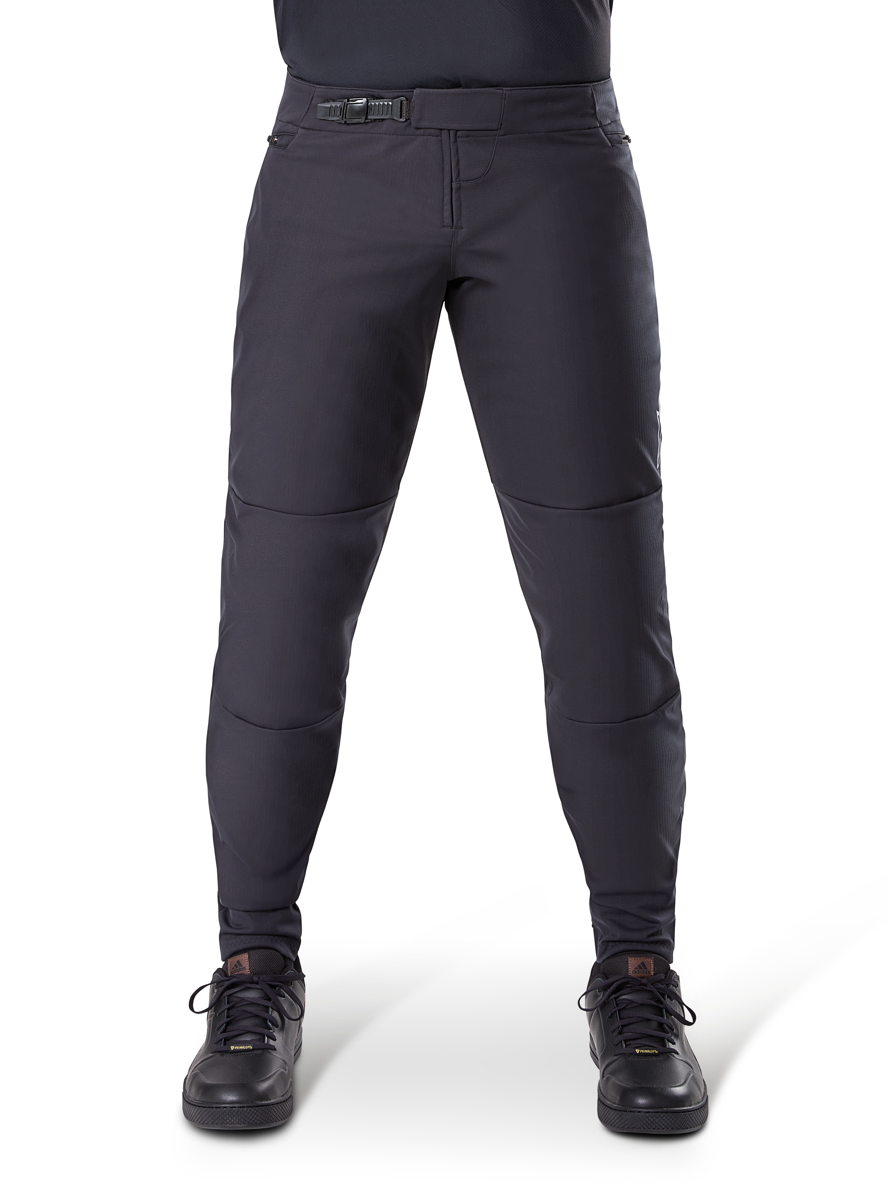 Pantalon thermique Alpinestars A-Dura, pantalon de VTT noir avec fermeture à cliquet sécurisée et coupe pré-courbée, porté avec des chaussures de cyclisme noires, matériau technique durable pour le VTT par temps froid