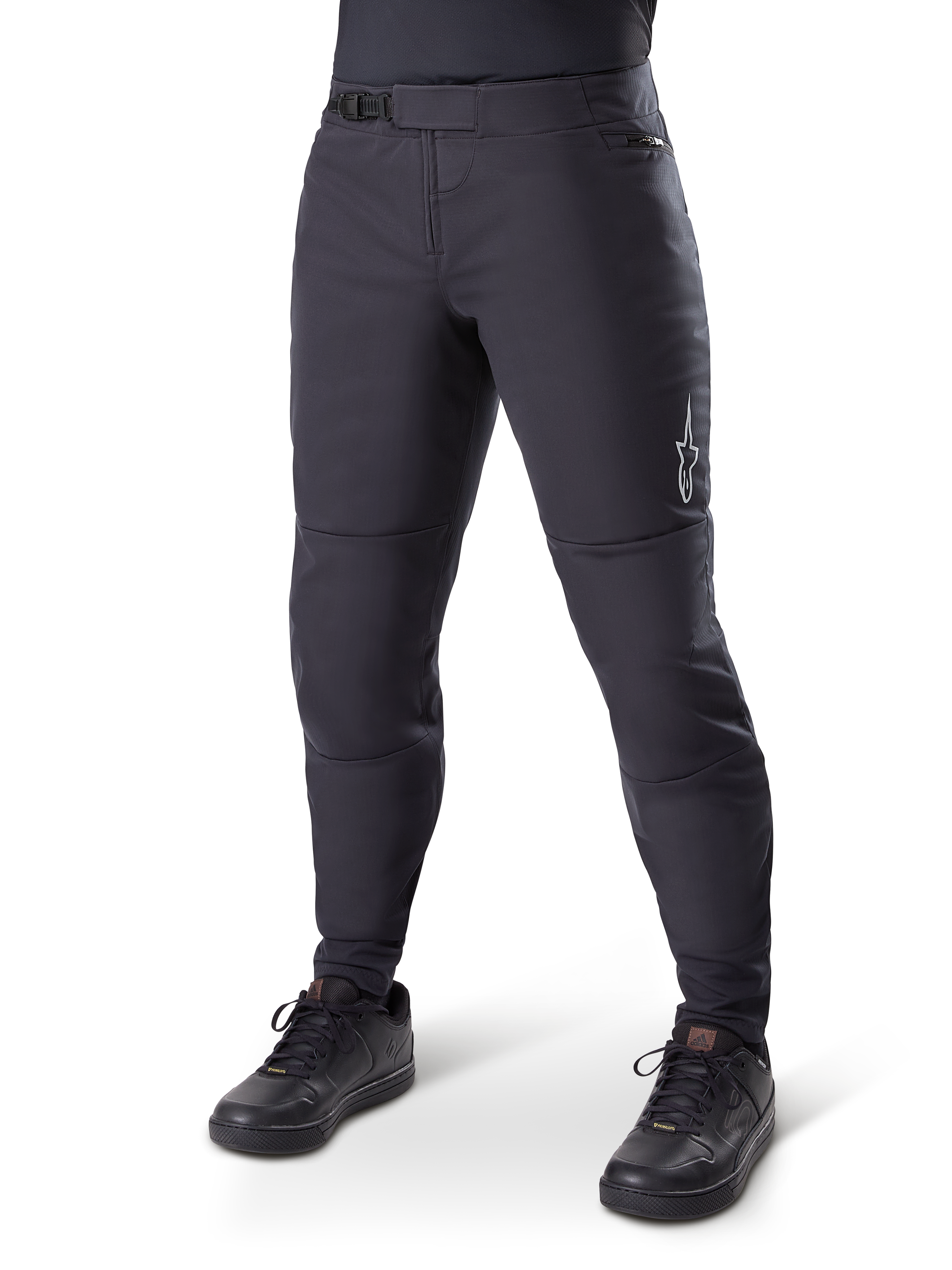 Alpinestars A-Dura Thermal Pant, pantalon de VTT noir, porté avec des chaussures de cyclisme noires, doté d'une fermeture à cliquet à la taille, petit logo blanc sur la cuisse, coupe ajustée pour le cyclisme par temps froid