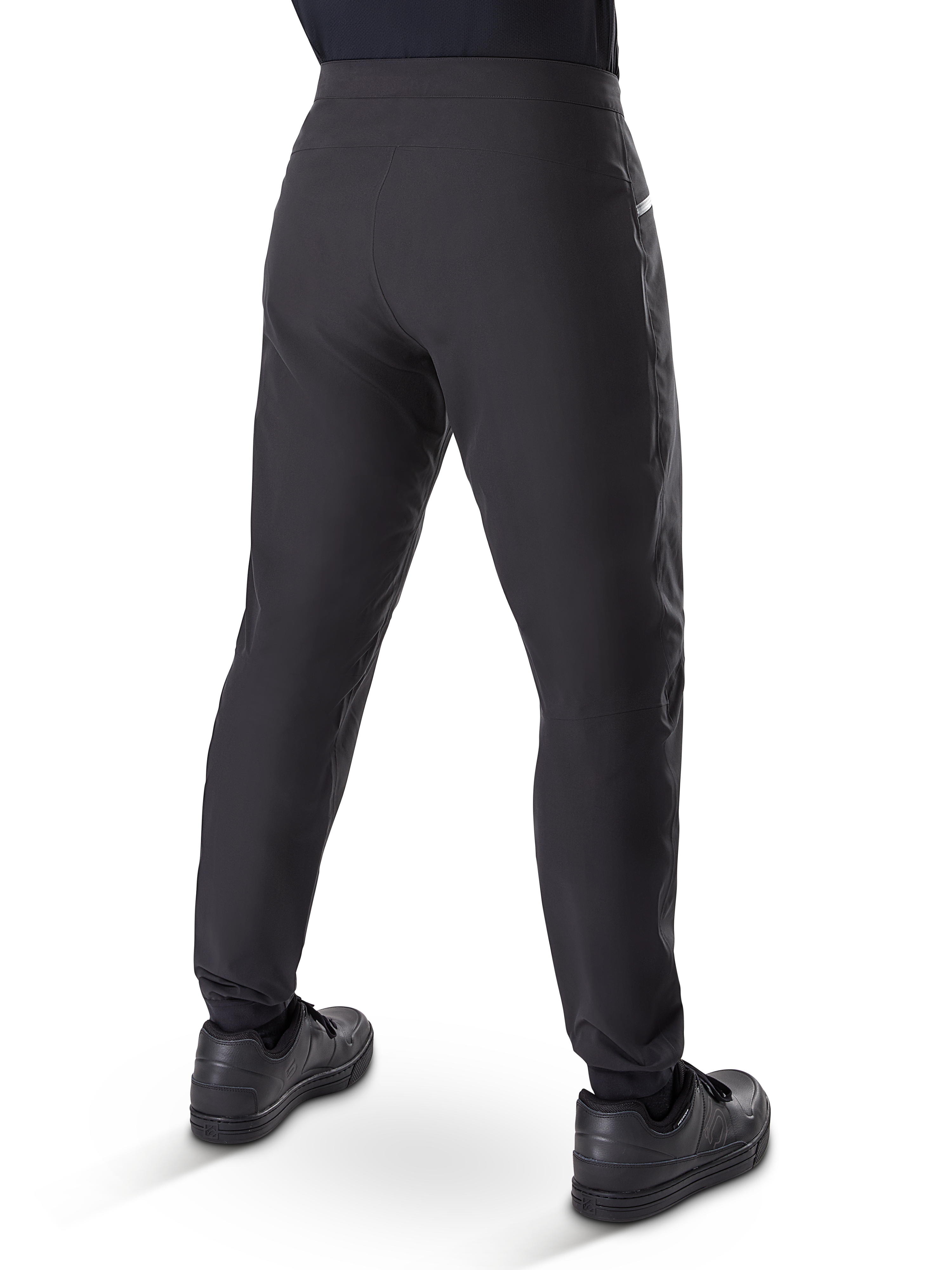 Pantalon imperméable Alpinestars A-Dura, pantalon de VTT, noir, vue arrière porté avec des chaussures noires, doté d'une membrane durable à 3 couches, coupe régulière et poignets élastiqués pour le cyclisme tout-terrain