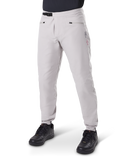 Pantalon imperméable Alpinestars A-Dura, pantalon de VTT, gris titane, doté d'une fermeture à cliquet noire à la taille et de poches zippées, jambes fuselées avec poignets élastiqués, porté avec des chaussures noires, construction imperméable 3L durable pour le cyclisme tout-terrain