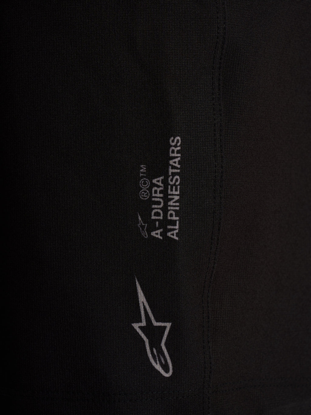 Détail du short Alpinestars A-Dura Ride Liner noir, logos blancs sur tissu technique extensible 4 directions.