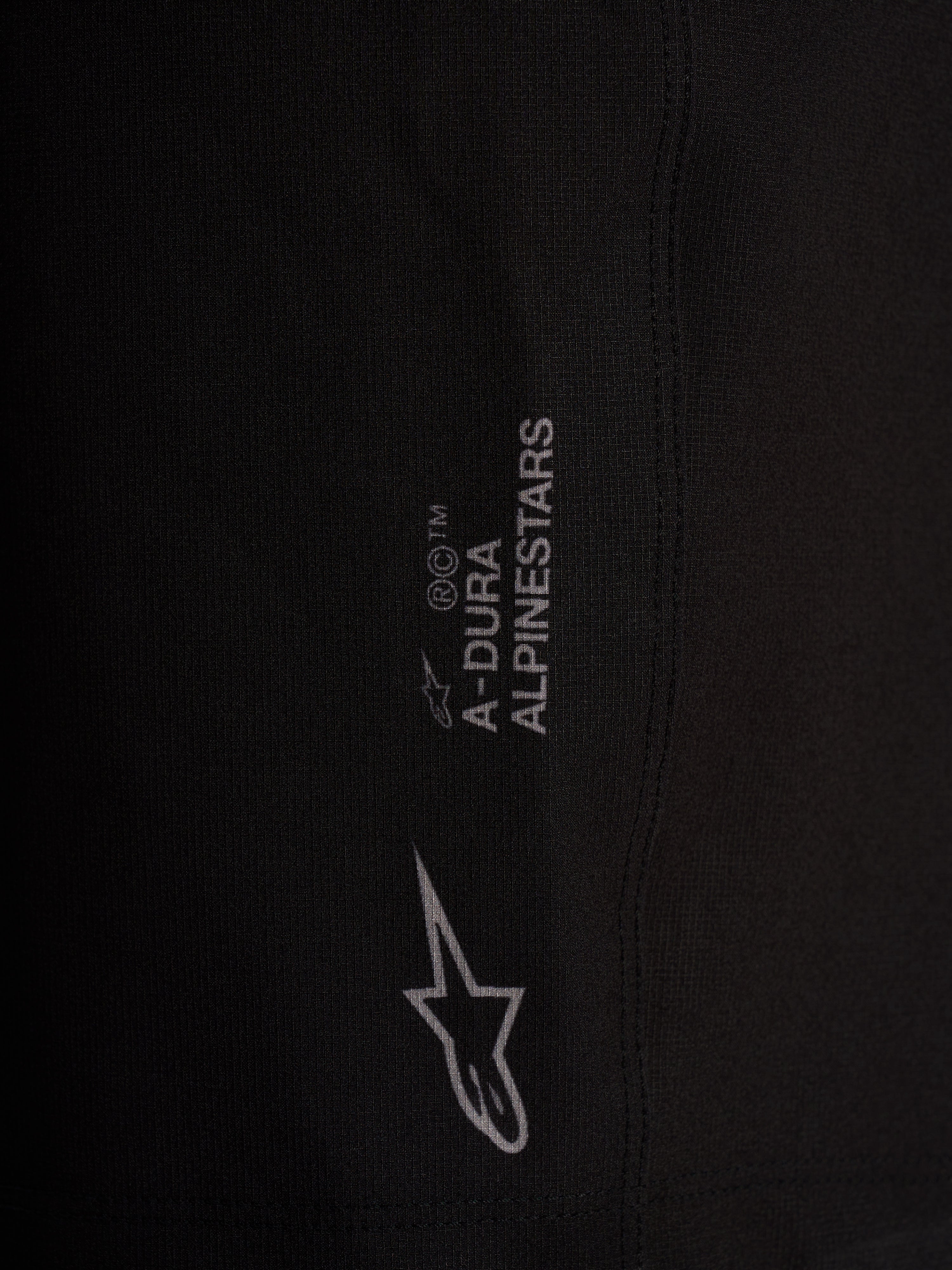 Détail du short Alpinestars A-Dura Ride Liner noir, logos blancs sur tissu technique extensible 4 directions.
