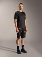 Short Alpinestars A-Dura Ride Black Camo, motif camouflage gris, porté avec un maillot et des chaussures de VTT noirs.