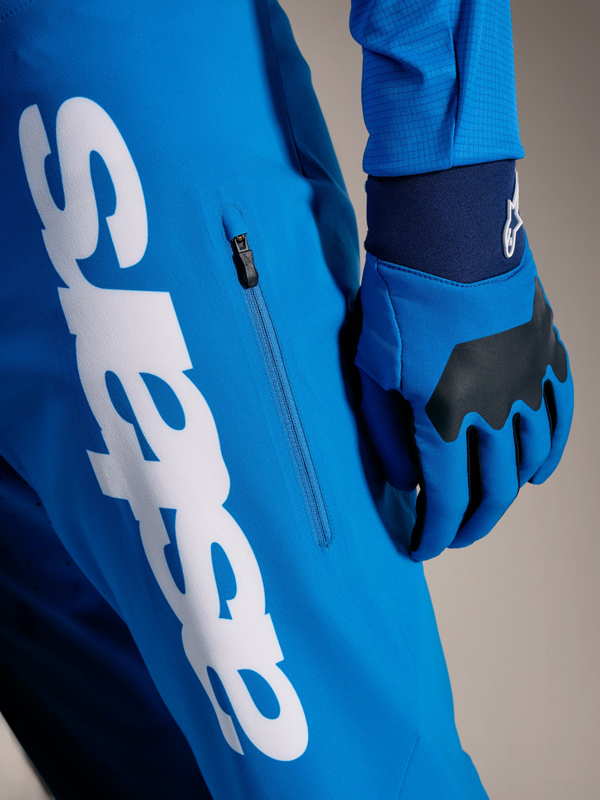 Pantalon VTT A-Supra Elite bleu vif délavé, logo Astars blanc et poche zippée verticale, équipement Alpinestars.