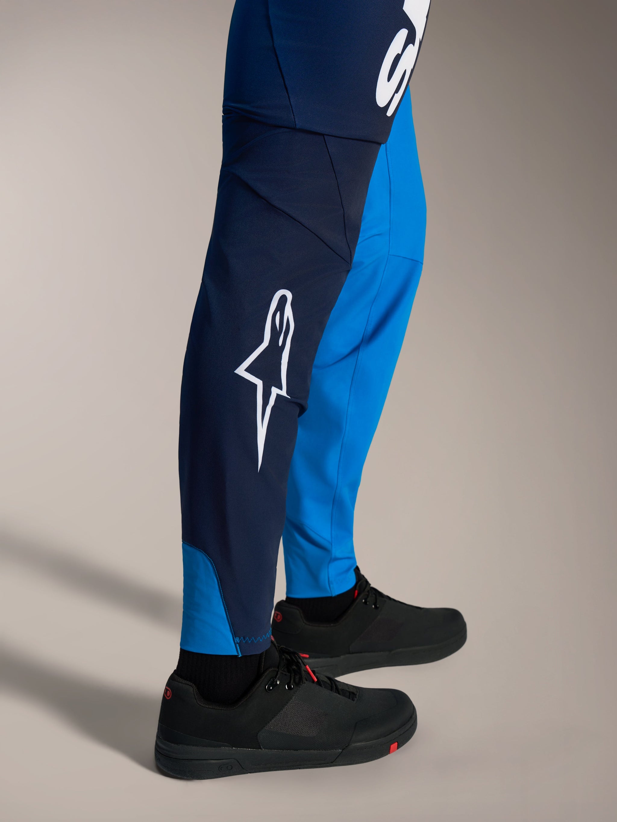 Pantalon VTT A-Supra Elite bleu vif délavé, avec logo Astars blanc et coupe racing ajustée.