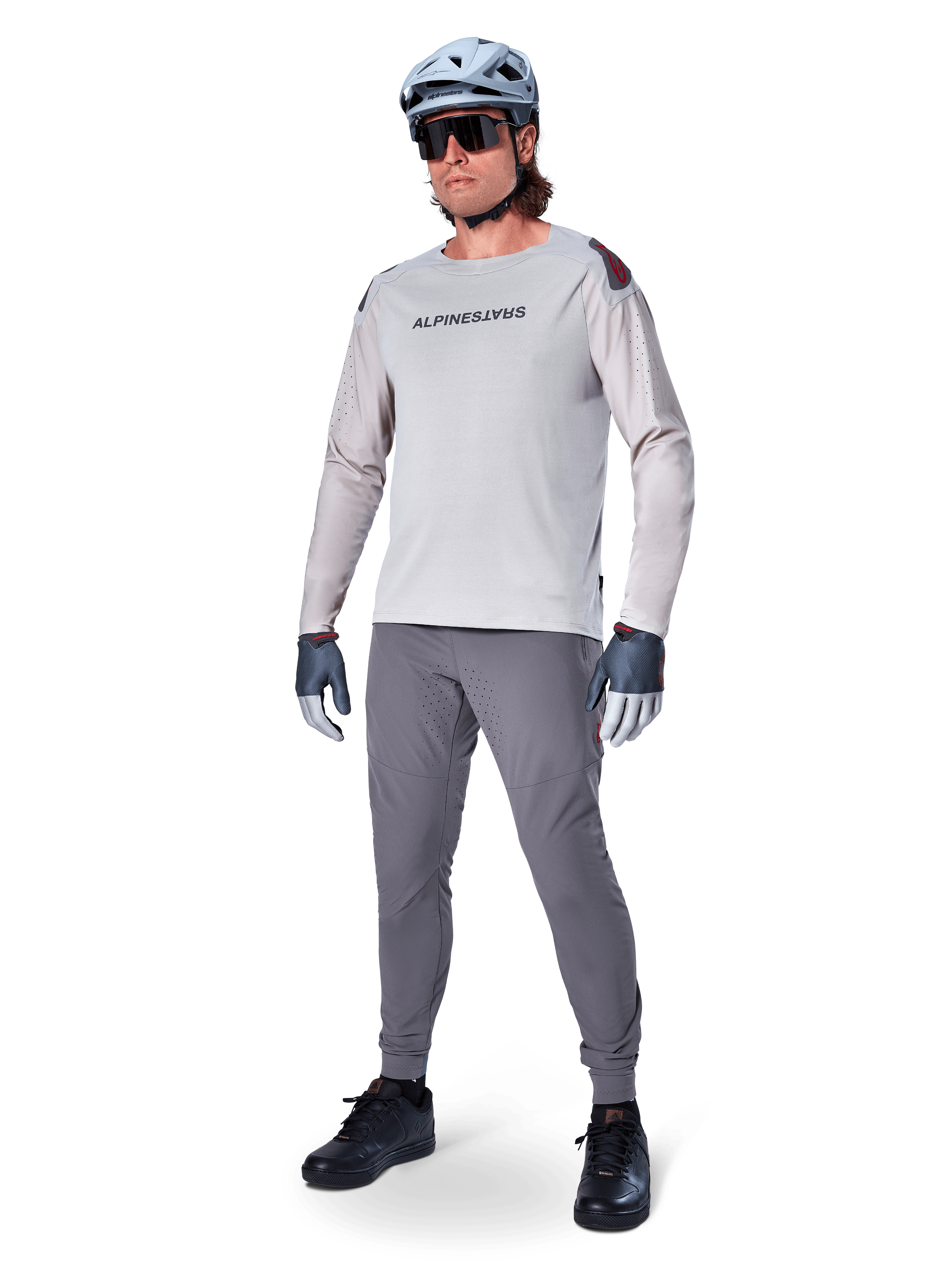 Alpinestars A-Aria Elite Pants, Dark Gray MTB Pants, worn by a rider with a light gray long-sleeve jersey and gray helmet, featuring laser-cut ventilation on the thighs and a tapered performance fit for mountain biking.