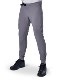 Alpinestars A-Aria Elite Pants, Dark Gray MTB Pants, laser perforated panels on thighs, black magnetic buckle closure, zippered pocket, red logo detail, slim performance fit, worn with black shoes