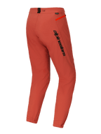 Alpinestars A-Dura Elite Pants, Mountain Bike (MTB) Pants, Dark Orange, rear three-quarter view featuring bold black Alpinestars branding on the thigh, bright orange zipper accent on the hip, and elasticated ankle cuffs, technical performance cycling gear
