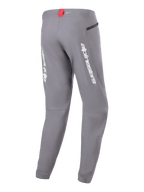 Pantalon Alpinestars A-Dura Elite, pantalon de cyclisme VTT, gris foncé, vue arrière avec logo Alpinestars blanc sur les jambes, petite étiquette rouge à la taille et poche zippée, conception technique pour le VTT