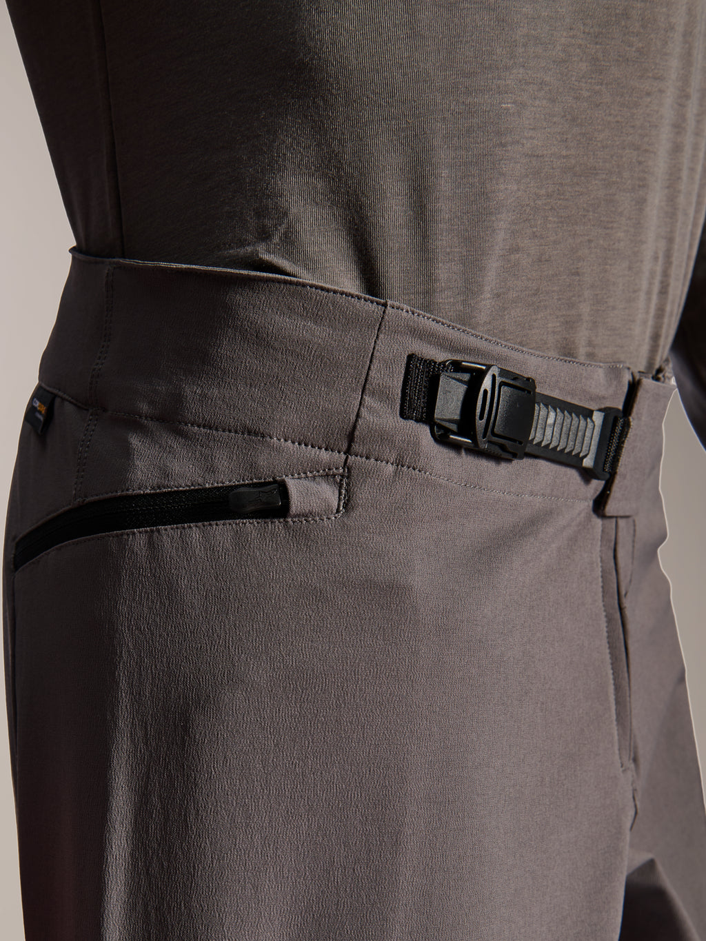 Pantalon Alpinestars A-Dura Elite, pantalon de VTT, gris foncé, vue rapprochée montrant le système de fermeture à cliquet à l'avant et la poche zippée, équipement technique de cyclisme pour le VTT