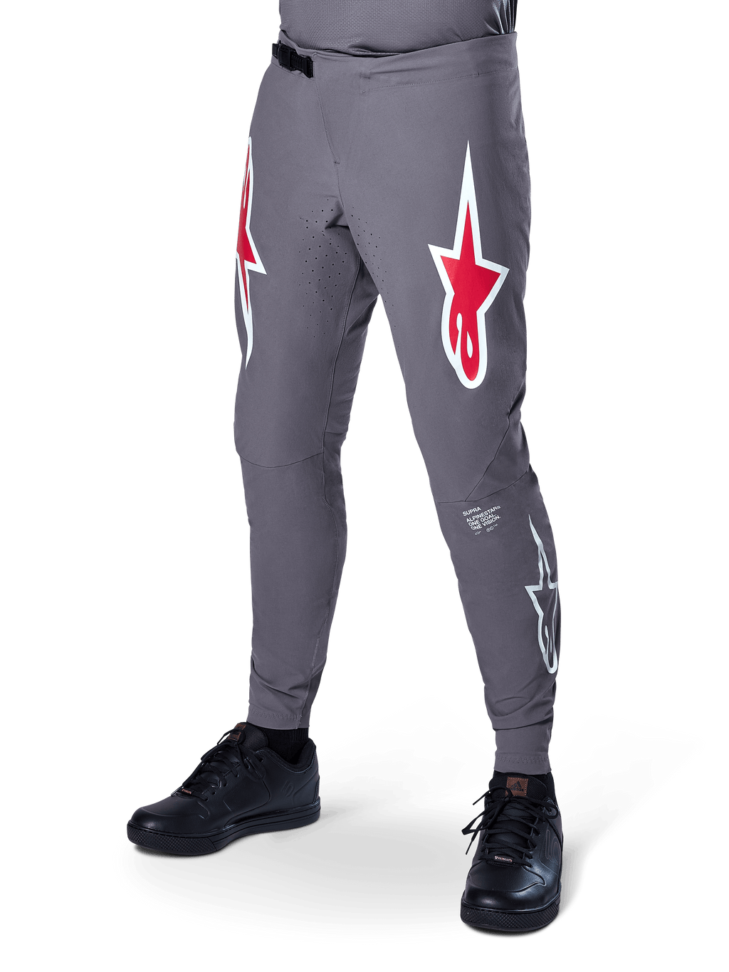 Pantalon Alpinestars A-Supra Race, pantalon de VTT gris foncé, avec grands logos étoile rouges et blancs sur les cuisses, ventilation perforée au laser et fermeture à rochet à la taille, coupe performance pour le downhill et l'enduro