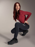 Pantalon thermique Alpinestars Stella A-Dura, pantalon de VTT pour femme, noir, porté par un mannequin accroupi avec un haut bordeaux à manches longues et des chaussures de cyclisme noires, logo étoile blanc sur la cuisse, construction chaude et durable pour les sorties tout-terrain par temps froid