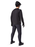 Alpinestars A-Dura Thermal Jersey, Men's Long-Sleeve Cycling Jersey, Black, rear view on model wearing a black MTB helmet, dark grey pants, and black gloves, professional mountain bike apparel for cold weather