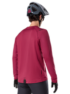 Maillot thermique Alpinestars A-Dura, maillot de VTT à manches longues, bordeaux, vue de dos d'un mannequin portant un casque de VTT gris et des gants noirs, doté d'un pan arrière allongé et de petits logos, conçu pour les sorties sur sentiers par temps froid.