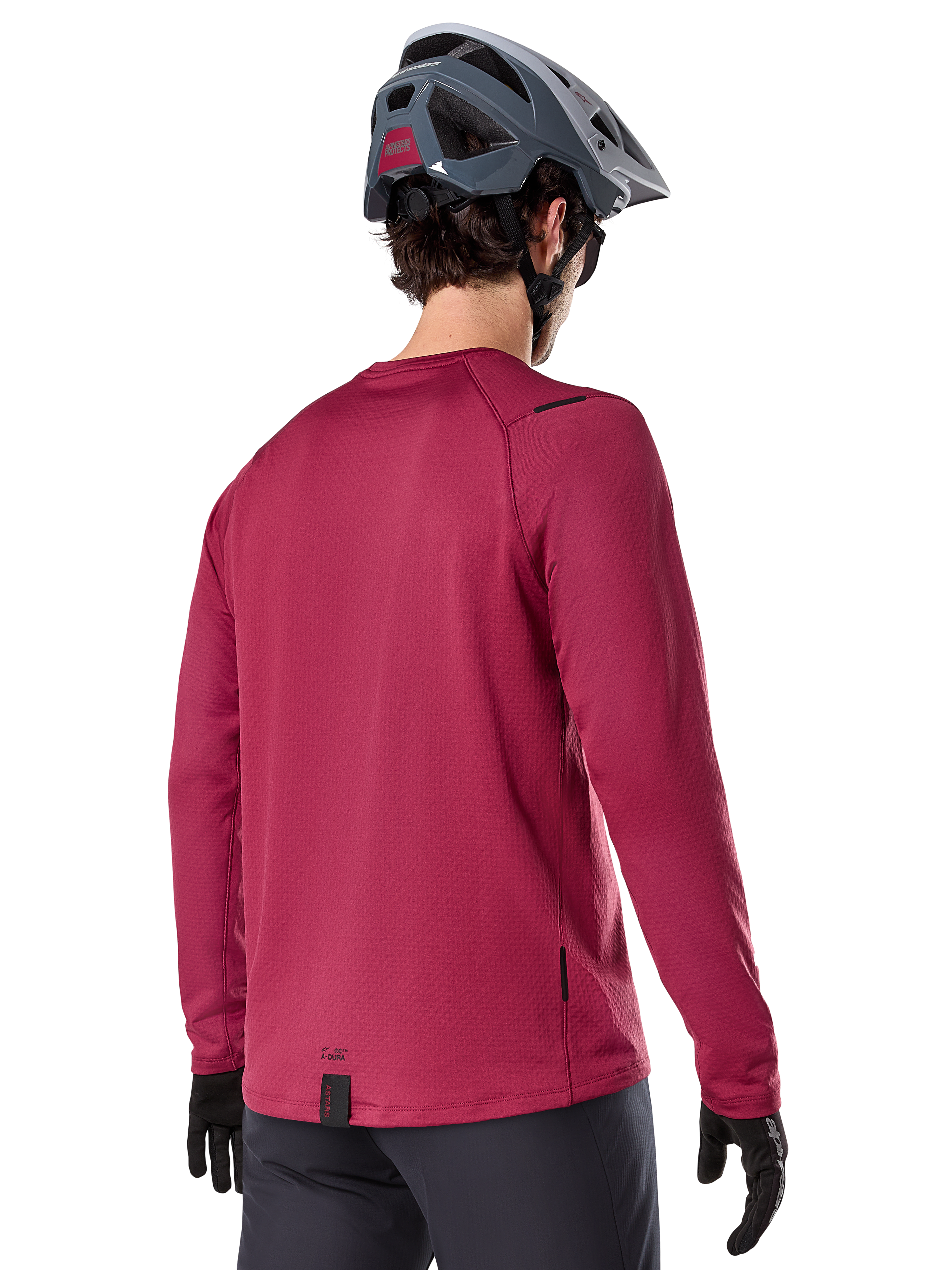 Maillot thermique Alpinestars A-Dura, maillot de VTT à manches longues, bordeaux, vue de dos d'un mannequin portant un casque de VTT gris et des gants noirs, doté d'un pan arrière allongé et de petits logos, conçu pour les sorties sur sentiers par temps froid.