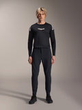 Alpinestars A-Aria Elite Pants, Black Titanium MTB Pants, worn by a male model with a matching black long-sleeve jersey and sneakers, slim-fit performance design with magnetic buckle closure, technical mountain bike apparel