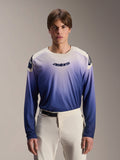 Alpinestars A-Aria Polartec Maker Elite Jersey, Long Sleeve MTB Jersey, Baja Blue with white-to-blue gradient, worn by a model with white pants, featuring dark blue chest logo and laser perforations on sleeves, performance mountain biking apparel