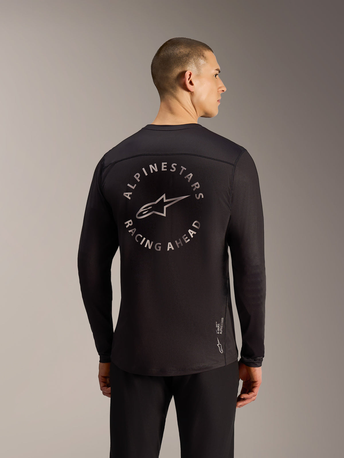 Maillot noir A-Dura Air à manches longues, vue arrière avec logo Alpinestars Racing Ahead et tissu mesh respirant.