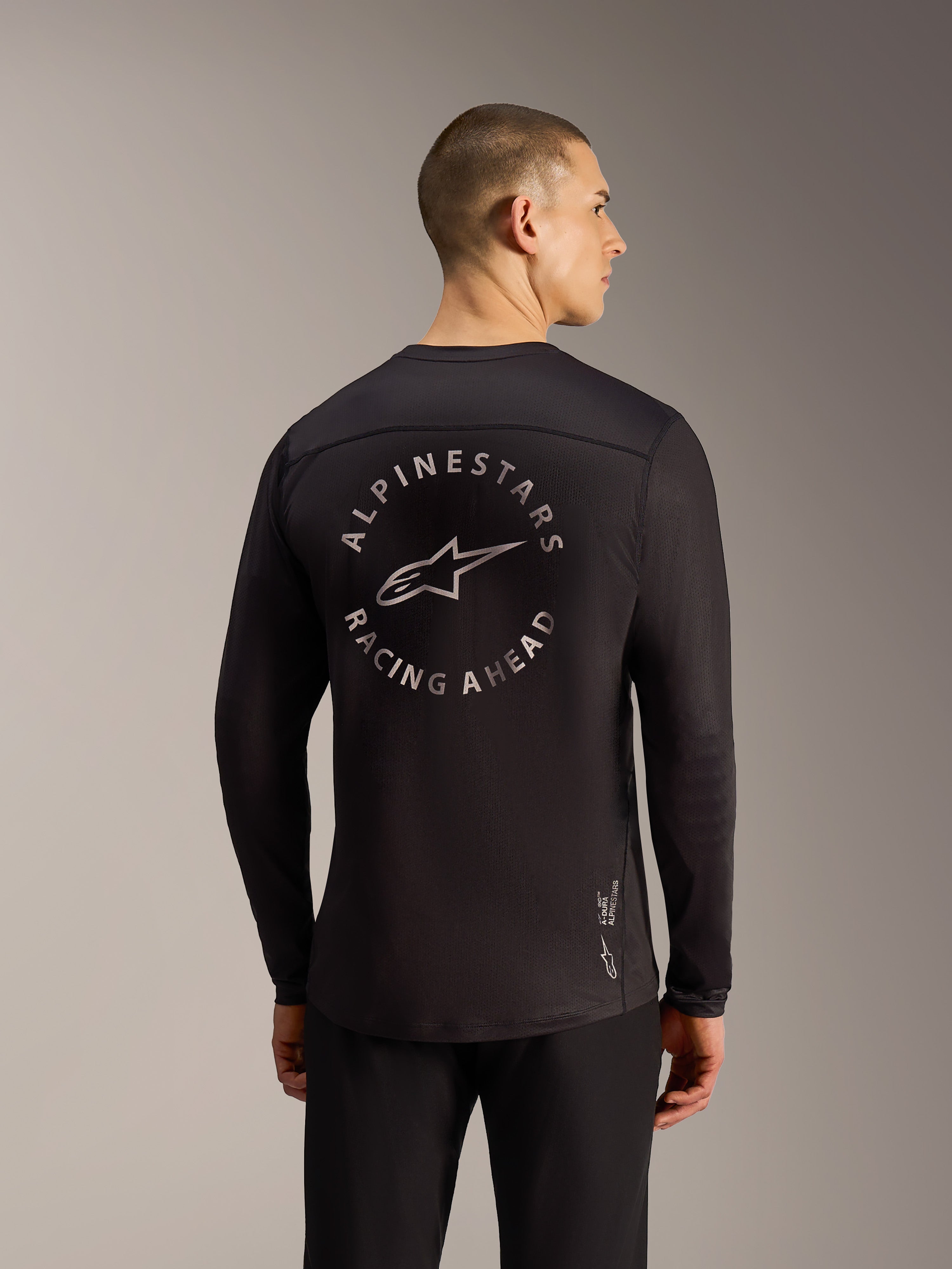 Maillot noir A-Dura Air à manches longues, vue arrière avec logo Alpinestars Racing Ahead et tissu mesh respirant.